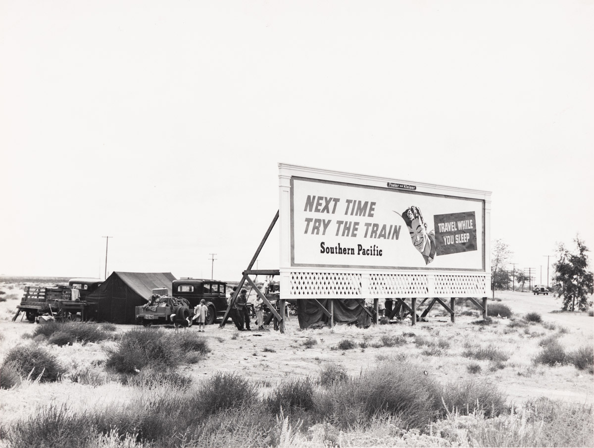 DOROTHEA LANGE (1895-1965) Three families camped on the plains along U.S. 99 near Formosa, Calif. They are camped behind a billboard wi